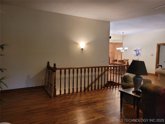 staircase with hardwood / wood-style floors and a chandelier