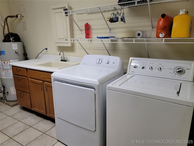 laundry room with light tile patterned flooring, water heater, sink, cabinets, and washing machine and clothes dryer