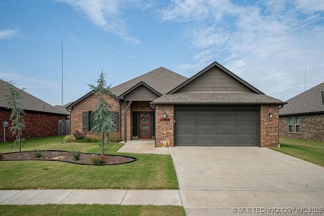 single story home featuring a garage and a front yard