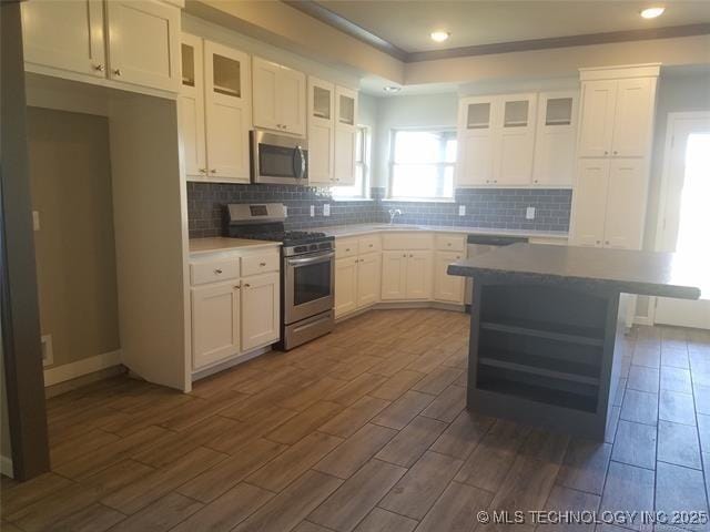 kitchen featuring sink, white cabinetry, stainless steel appliances, tasteful backsplash, and dark hardwood / wood-style flooring