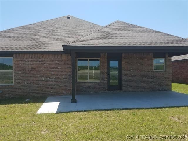 back of house with a patio area and a lawn