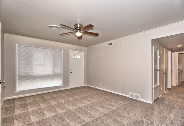 empty room featuring ceiling fan, ornamental molding, and carpet