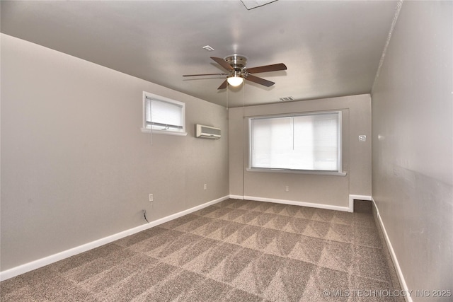 empty room with ceiling fan, carpet floors, and a wall unit AC