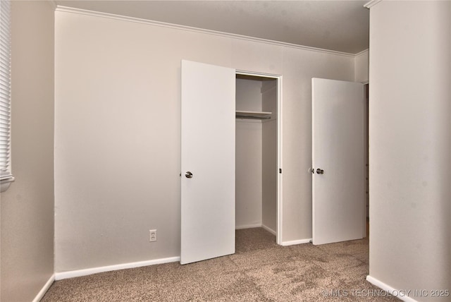 unfurnished bedroom with a closet, ornamental molding, and carpet