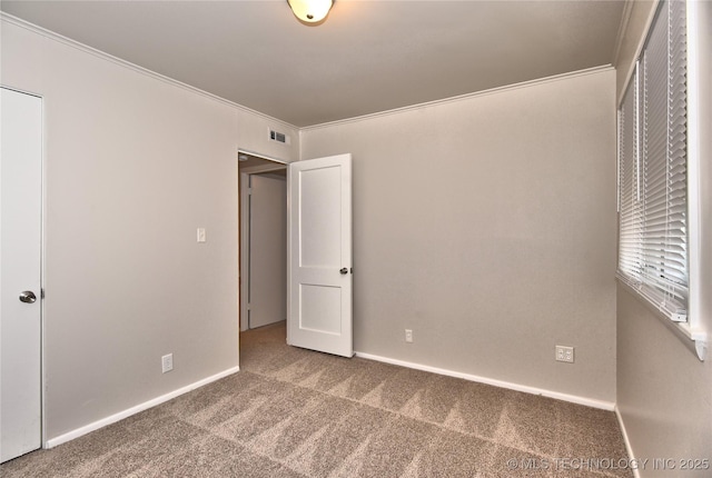 unfurnished bedroom featuring crown molding and carpet flooring