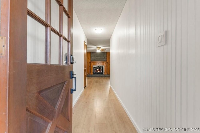 corridor featuring a textured ceiling and light wood-type flooring