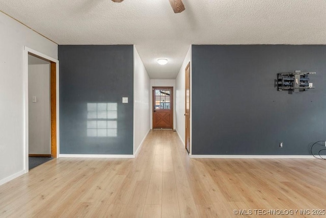 hall featuring a textured ceiling and light wood-type flooring