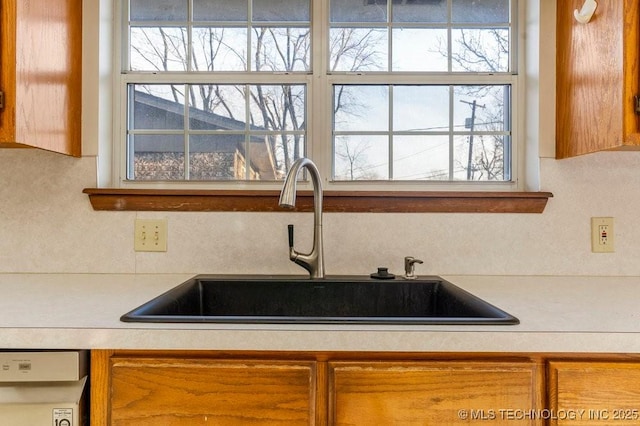 kitchen featuring dishwasher, sink, and decorative backsplash