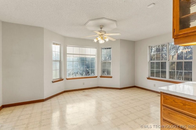 interior space featuring ceiling fan, a textured ceiling, and a healthy amount of sunlight