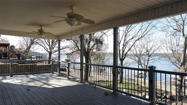 wooden deck with ceiling fan and a water view