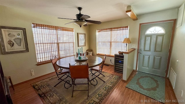 dining space featuring wine cooler, ceiling fan, and hardwood / wood-style floors