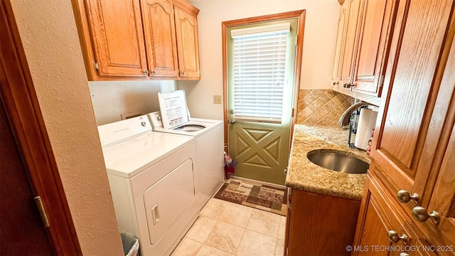 laundry area featuring cabinets, separate washer and dryer, and sink