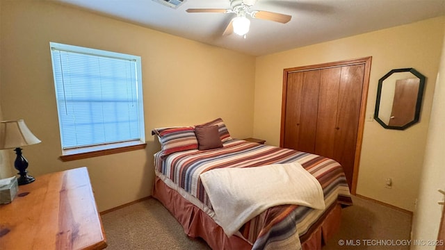 carpeted bedroom featuring ceiling fan and a closet