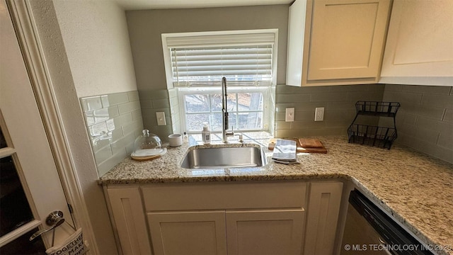 kitchen featuring sink, stainless steel dishwasher, light stone counters, and decorative backsplash