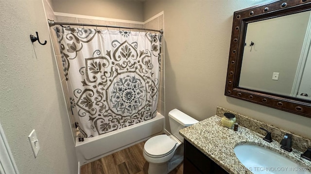 full bathroom with shower / bath combo, hardwood / wood-style floors, vanity, and toilet