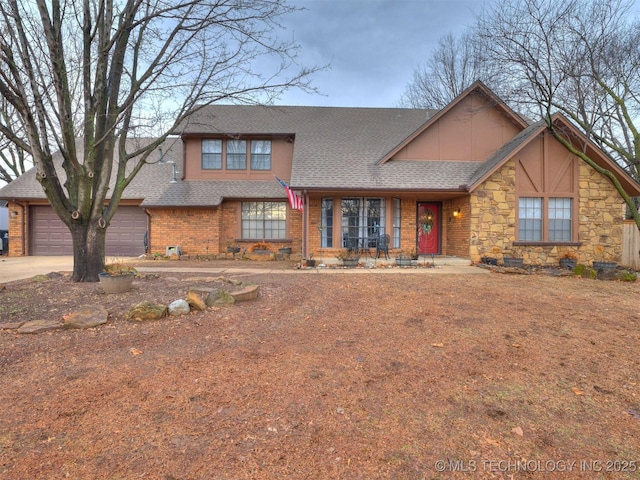 view of front of home featuring roof with shingles, brick siding, an attached garage, stone siding, and driveway