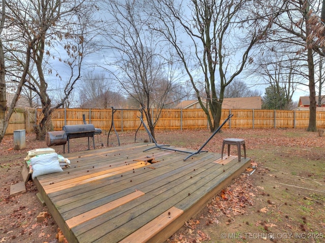 wooden deck with a fenced backyard