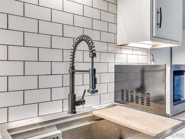 room details with decorative backsplash, a sink, and light countertops