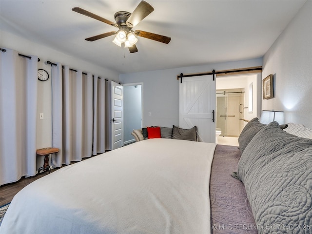 bedroom featuring ceiling fan, a barn door, and ensuite bath