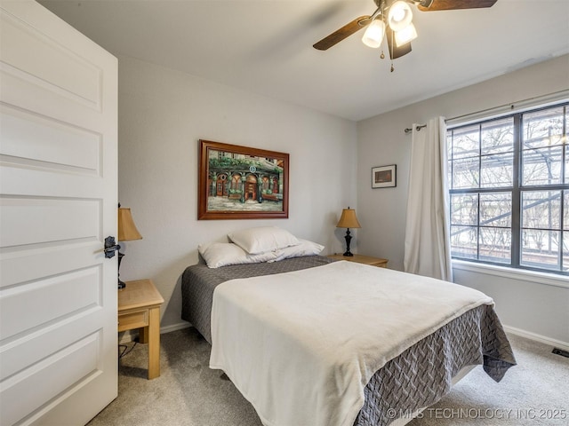 bedroom featuring light carpet, baseboards, multiple windows, and visible vents