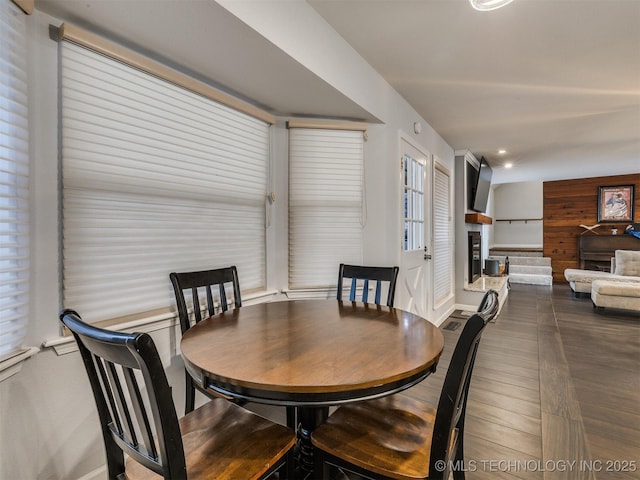 dining space featuring a fireplace, wood finished floors, and recessed lighting