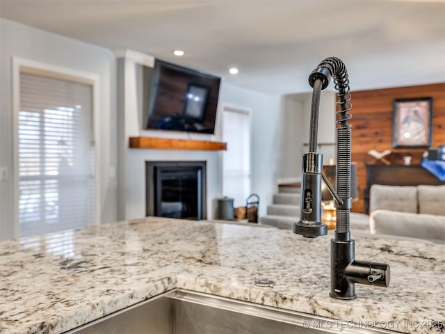 kitchen with recessed lighting, open floor plan, a fireplace, and wood walls