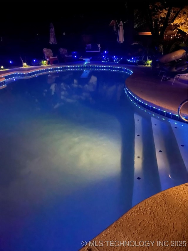 pool at night with an outdoor pool