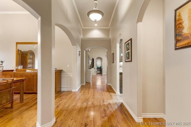 corridor with crown molding and light hardwood / wood-style floors