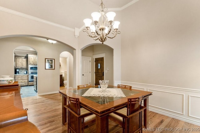 dining room featuring crown molding, a chandelier, and light hardwood / wood-style flooring