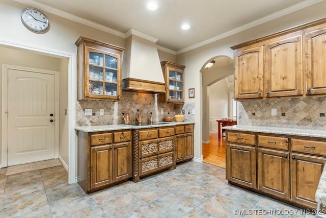 kitchen with black electric cooktop, decorative backsplash, crown molding, and custom exhaust hood