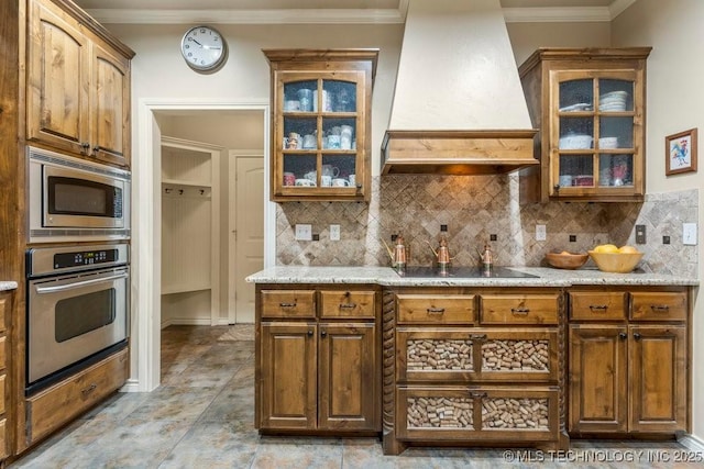 kitchen with custom exhaust hood, ornamental molding, decorative backsplash, and stainless steel appliances