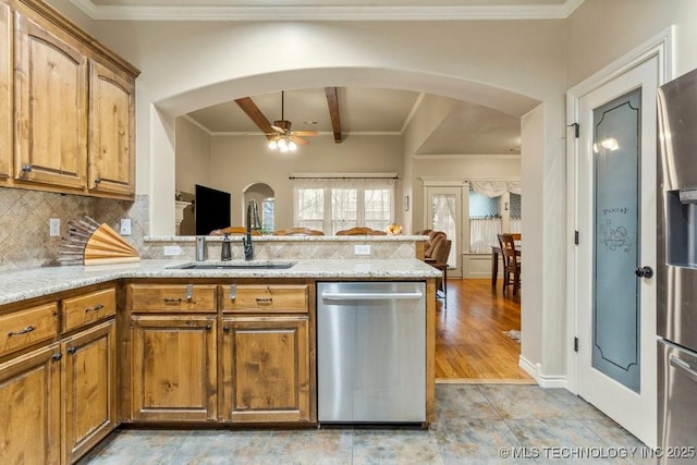 kitchen with sink, backsplash, light stone counters, kitchen peninsula, and stainless steel appliances