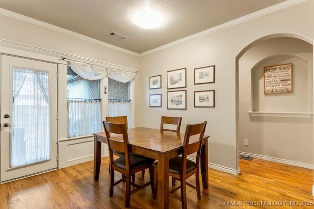 dining space featuring crown molding and hardwood / wood-style flooring