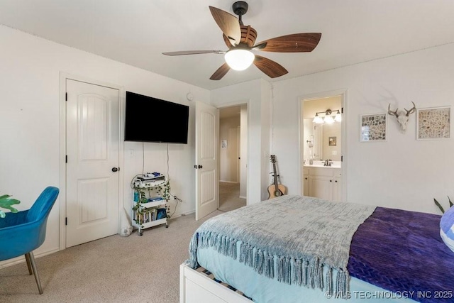 carpeted bedroom with ensuite bathroom, sink, and ceiling fan