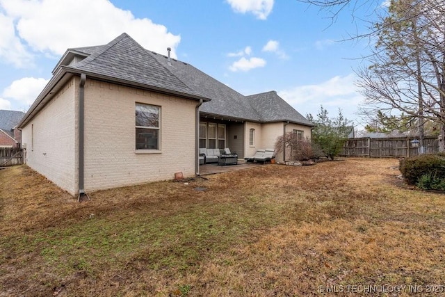 back of property with a patio and a lawn