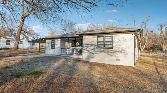 view of front of home with a porch, a carport, and a front yard