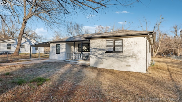 view of front of home with a front lawn, a carport, and a porch