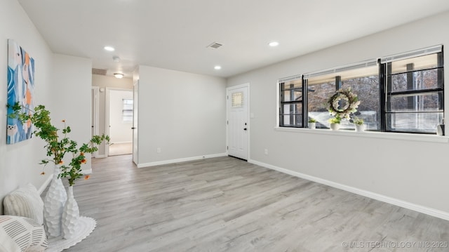 spare room featuring a healthy amount of sunlight and light hardwood / wood-style flooring