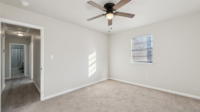 carpeted empty room with ceiling fan and plenty of natural light