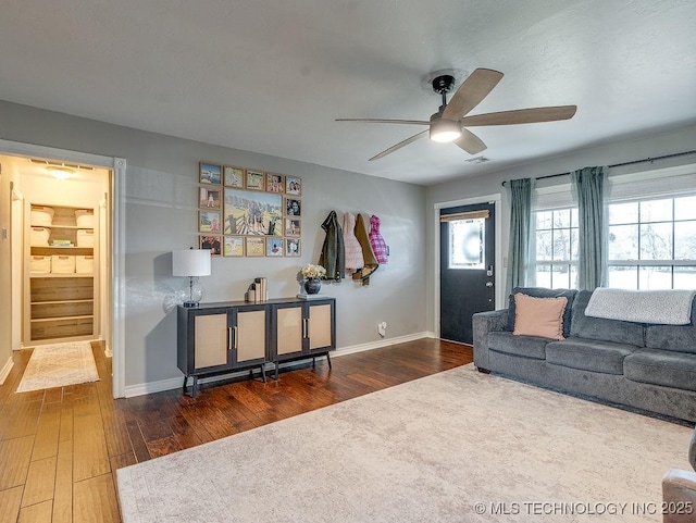 living room with dark wood-type flooring and ceiling fan