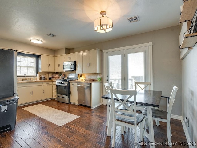 kitchen featuring stainless steel appliances, dark wood-type flooring, and white cabinets