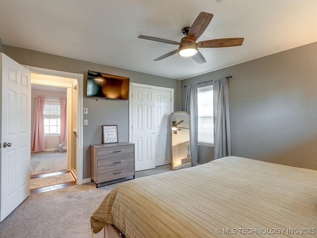 carpeted bedroom featuring ceiling fan and a closet