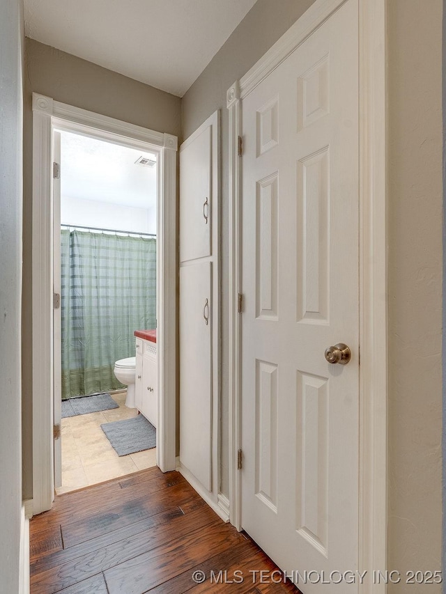 corridor with dark hardwood / wood-style flooring