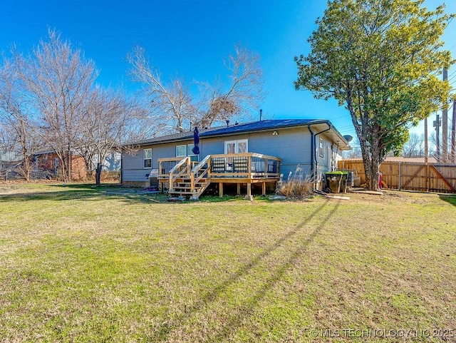 rear view of house featuring a yard and a deck