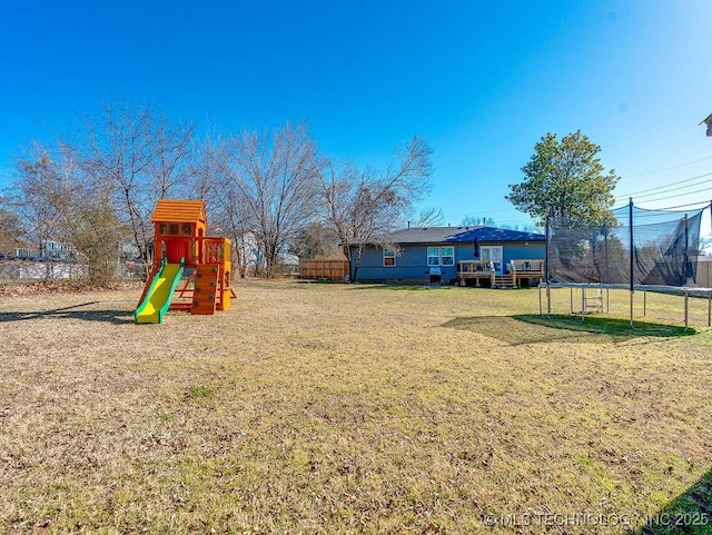 view of yard featuring a trampoline and a playground