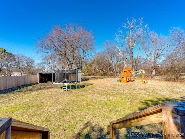 view of yard featuring a trampoline and a playground