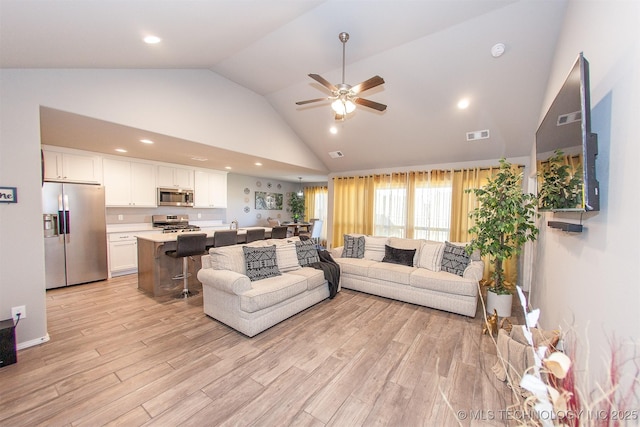 living room featuring high vaulted ceiling, ceiling fan, and light hardwood / wood-style flooring