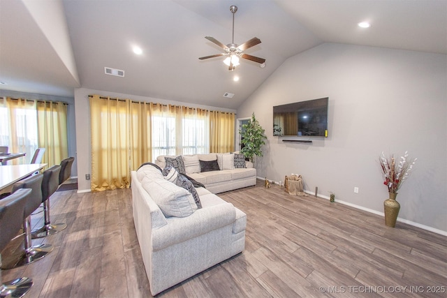 living room featuring wood-type flooring, plenty of natural light, ceiling fan, and high vaulted ceiling