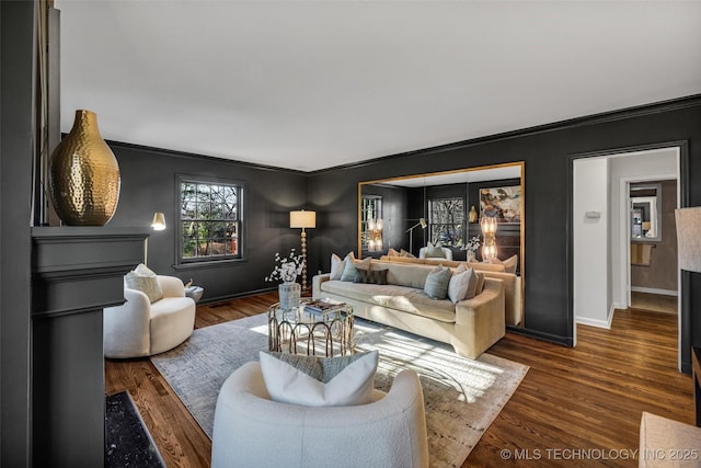 living room featuring ornamental molding, wood finished floors, and baseboards