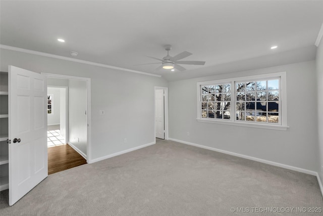 spare room with carpet flooring, crown molding, and baseboards